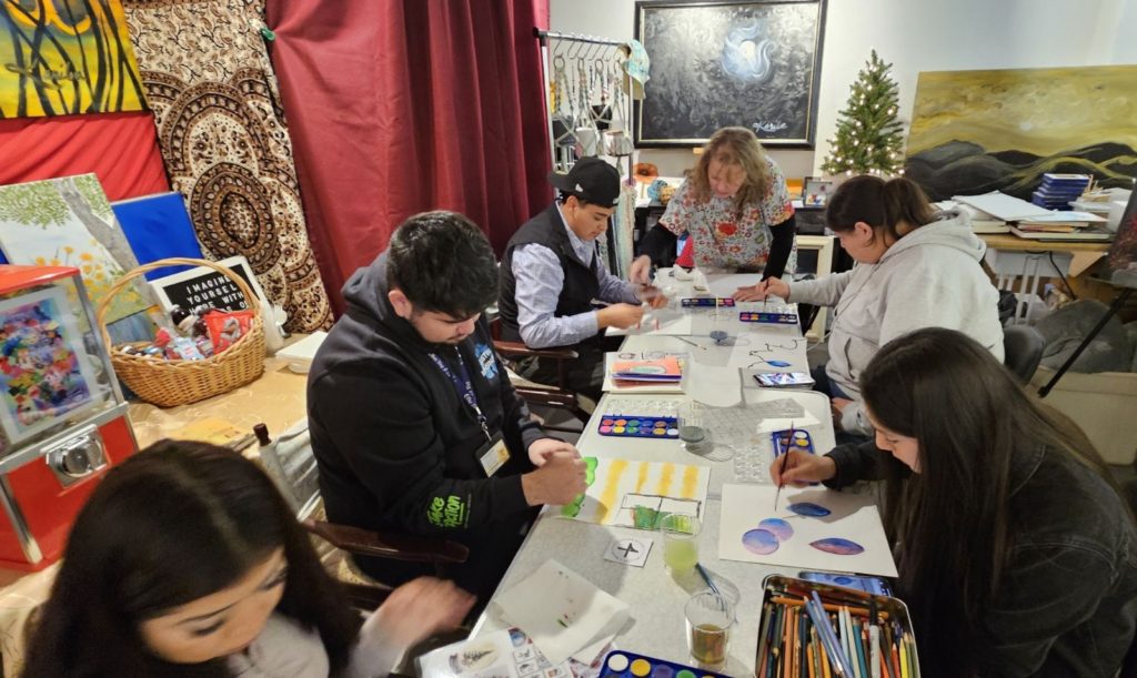 Kariba in her art studio with 6 other artists drawing and painting.